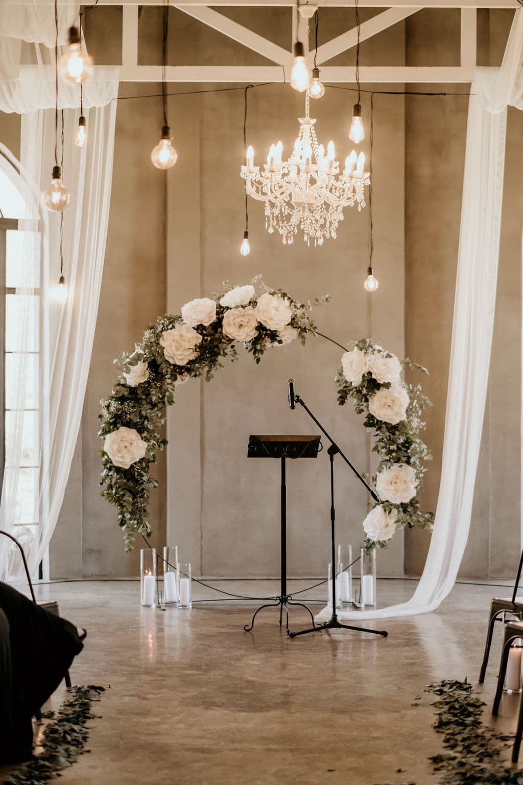 Large wedding at Ever Be Wedding Venue - Beautiful flower arch ceremony setup in French industrial chapel