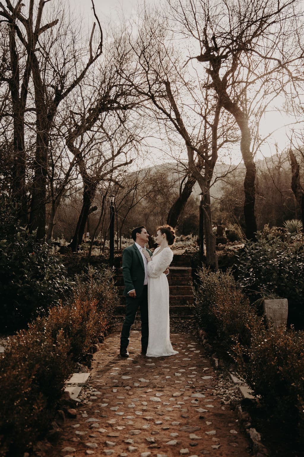 Bridal couple outside in front of steps with chandelier